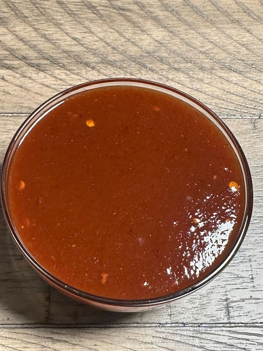 Bowl of J. Coleman's BBQ sauce on a wooden table